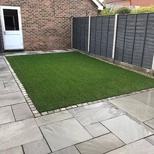 small patch of grass with grey patio