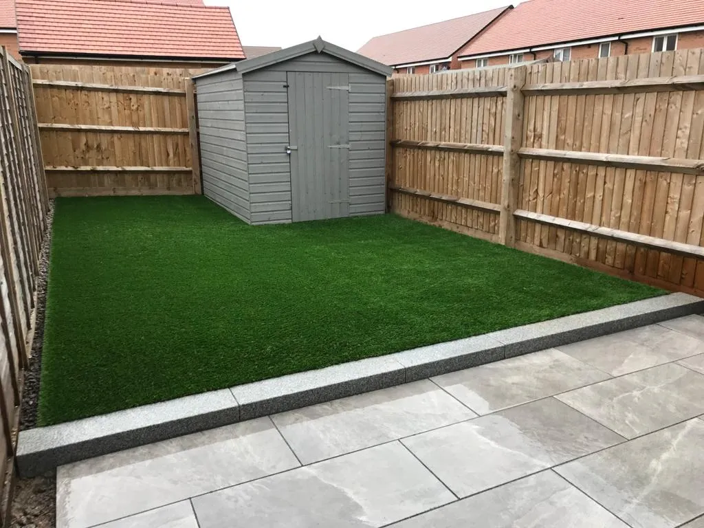 small patio with grass and shed